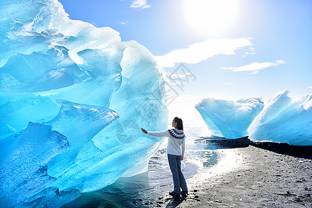 冰岛 在冰山海滩的惊人风景 冰山上的冰山游客 又名钻石海滩 由冰川泻湖/冰川湖自然 冰岛毛衣的女人图片