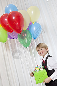 快乐的年轻生日男孩 与派对气球和礼物看远了倾斜年龄孩子微笑喜庆乐趣幸福服装休闲男性图片