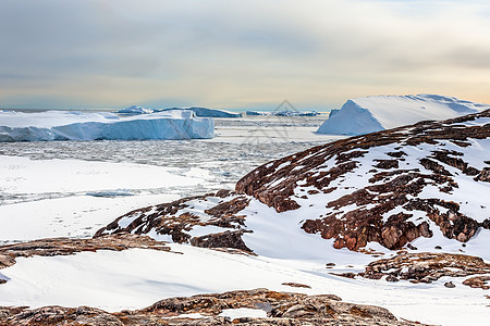 冰田和漂浮的冰山 表面有岩石图片