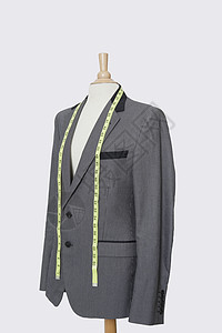 穿着灰色背景的测量胶带的裁缝假衣服男装设计时装男士工业生意外套纺织商业模型图片