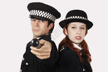 灰色背景下充满自信的警官一幅肖像成年手势警察制服女性警棍长度彩色两个人帽子图片