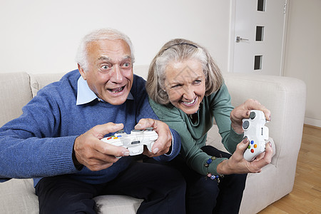 在家玩电子游戏的老年情侣中图片
