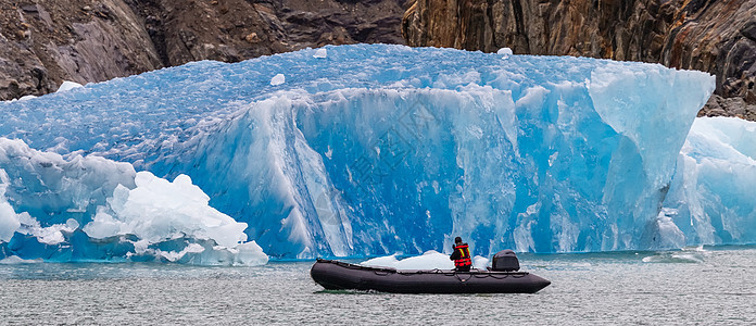 旅游者乘船在码头冰山航行快艇海洋冰山旅游环境救生衣蓝色冰川全球天空图片