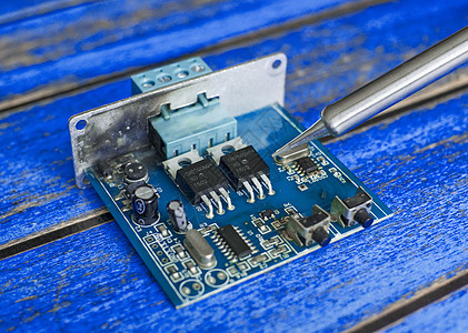 在用焊烫铁修理过程中损坏的电子板被损坏电路板打印电阻器技术处理器卡片绿色木板母板电子产品图片
