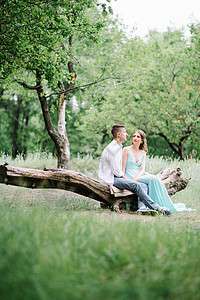 穿白衬衫的快乐男人 穿着绿绿色裙子的女孩灌木丛花园棕色森林新娘男朋友树木木头白色公园图片