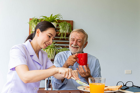 亚洲护士享受协助老年男子吃早餐和快乐的Tt午餐卫生援助保健感激食物护理人士照顾者擦洗图片