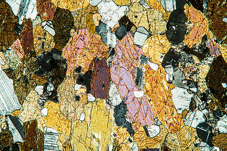 显微镜50x下的闪石岩岩石科学石英黑云母石榴石矿物质片段显微术宏观地幔图片