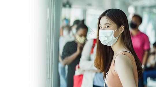 身戴外科面具和等候的年轻亚洲女乘客图片