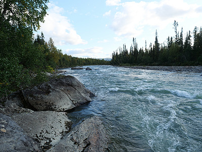 在瑞典拉普兰的有着野生冰川河流Kamajokk 巨石和树林的美丽的北部风景假期旅行蓝色流动石头溪流旅游自然公园时段戏剧性图片