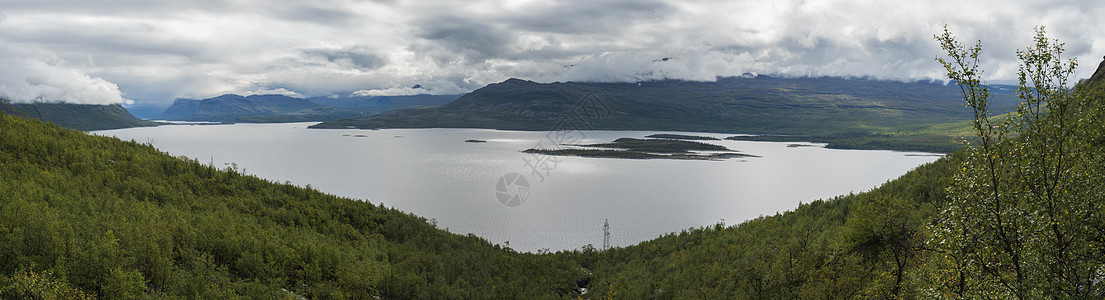 Kungsleden徒步足道 绿山和薄雾中白树林的Akkajaure湖全景景观图片