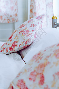 床上有花型枕头的明亮卧室内室内图案花卉家具汽车奢华寝具装饰房间摄影婚姻图片