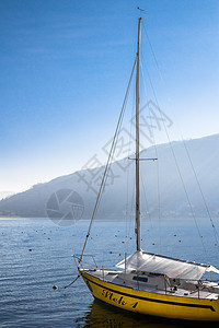 湖边游艇娱乐黄色桅杆天空湖景阳光航行帆船码头港口图片