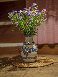 红紫罗兰花束 在生锈陶瓷中画的花瓶上图片