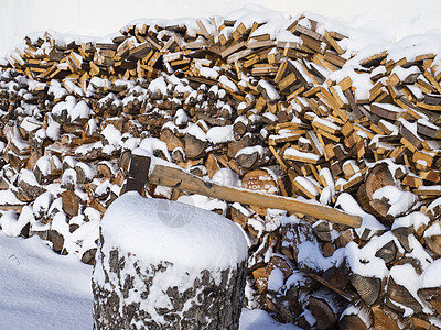 紧紧的斧子 挂在树干上 背着堆积的砍木柴 上面布满雪图片