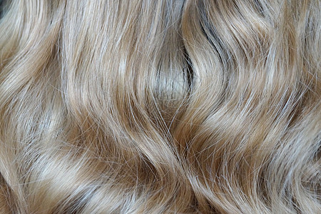 金色金发短长的卷毛 为背景而特写海浪纤维生长女士假发健康理发沙龙金发女郎染料图片