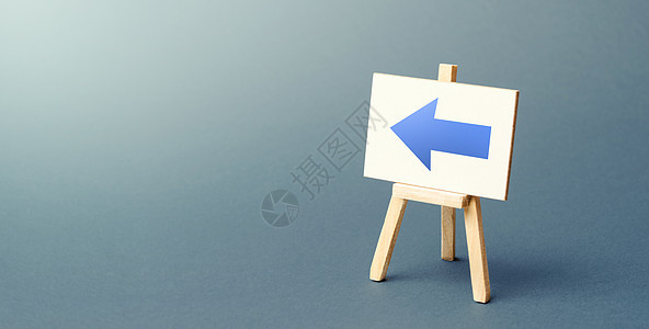 带有蓝色左箭头的画架 方向标志 商店或直销店位置的广告 极简主义 限制运动 改变路线 短路 分散注意力的动作图片