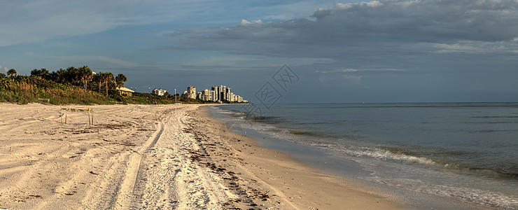 日落时 太阳在大海的云中窥视海岸海景结束热带海洋天空全景海滩海岸线图片