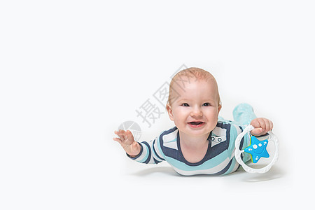 笑着的男孩躺在白色背景上 拿着玩具孩子男生喜悦婴儿微笑幸福儿童快乐男性童年图片