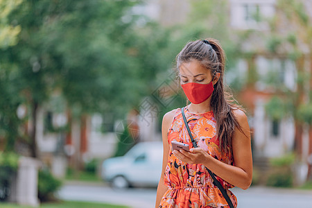 城市强制佩戴 COVID-19 口罩 亚洲女性在城市公园夏季户外生活方式中使用戴着面罩保护的手机行走 以预防冠状病毒 新冠病毒图片