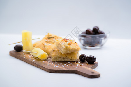 意大利花粉加洋葱 橄榄和奶酪水平砧板白色乡村面包小吃食物黑色迷迭香木头图片