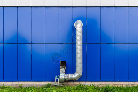 蓝色墙上装有电动发动机的工业级抽气管道空气扇子房子排放外卖金属发泄管子技术气体图片