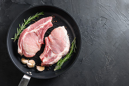 炒煎锅烧烤炉的猪肉烤肉和草药 香料最高视角黑石圆岩表面文字空间图片