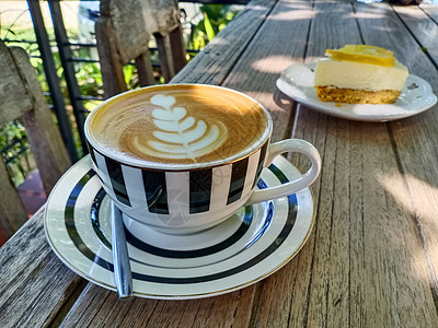 咖啡晚期艺术和一小片柠檬芝士蛋糕甜点作为食物图片