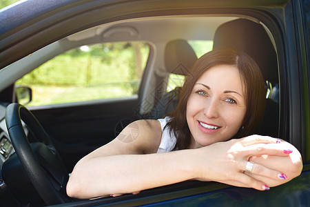 一个坐在车里的微笑着的女人的肖像 看着镜头女士运输乐趣好心情司机妇女头发驾驶喜悦女孩图片