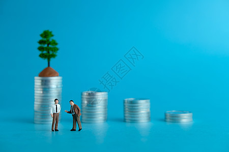 微型商业概念     两次商务人士在硬币堆叠阶梯前讨论 谈金融投资问题图片
