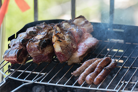 传统阿根廷和乌拉圭烧烤晚宴的近闭式肋骨香肠火焰奶牛午餐煤炭美食炙烤火盆余烬图片