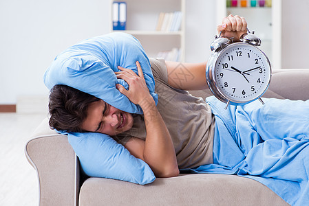 男人在闹钟后醒来时有困难卧室睡眠说谎时间压力恶梦苏醒疾病失眠沙发图片