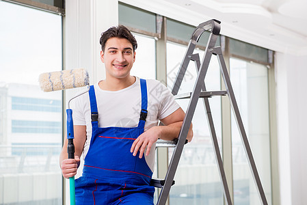 在建筑工地工作的油漆修理工滚筒男性承包商房间梯子微笑画家工人画笔装潢师图片