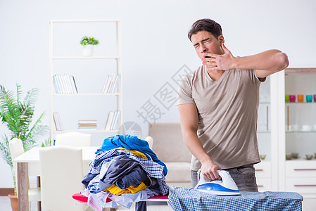 年轻男子丈夫在家穿衣服熨衣服工作男人女佣家庭午睡熨烫服务帮助外包工人图片