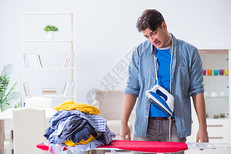 年轻男子丈夫在家穿衣服熨衣服服务蒸汽家庭清洁工外包房间帮助器具管家压力图片