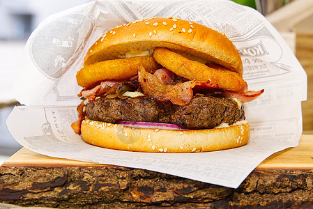 在木头胡须上的纸包里装汉堡 在木板上做美味的汉堡图片