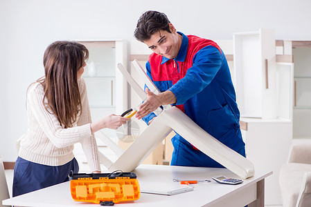 由妇女看管的家具组装工程工修理工房子桌子男人乐器扶手椅工具工具箱集会工作作坊图片