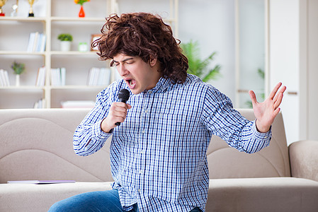 在家唱卡拉OK歌的有趣的男人俱乐部音乐家艺人假发音乐会麦克风娱乐记录卡拉ok演员图片