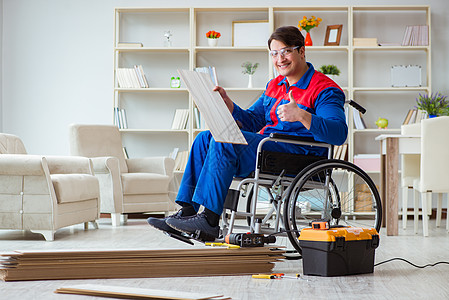 残疾人在办公室铺地板层的男子椅子轮椅工作残障工具箱工人木工人士地面车轮图片