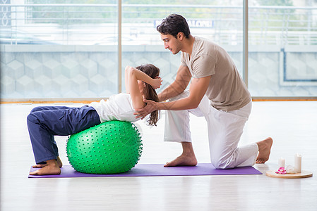 个人教练用稳定球帮助体操中的女子娱乐有氧运动健身房健身健康男人讲师瑜伽治疗重量图片