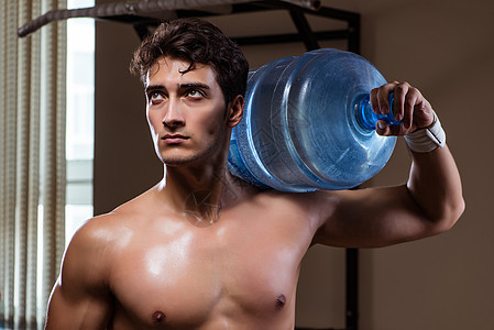使用大水瓶的肌肉撕裂人健康健美运动员活动力量男性肩膀锻炼身体娱乐图片
