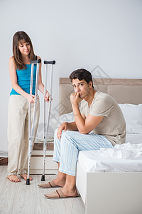 受伤后用拐杖支持丈夫的年轻妻子男人减值夫妻疾病帮助机动性关爱照顾者家庭卫生图片