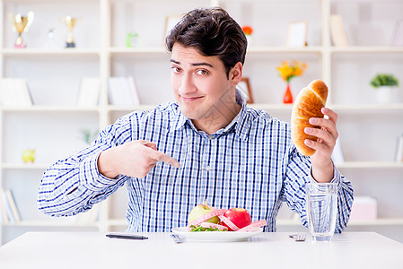 人类在饮食中有健康食物和面包的两难境地水果热狗餐厅烹饪早餐午餐包子困境营养男人图片