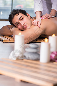温泉疗养期间的英俊年轻男子芳香治疗客厅护理毛巾沙龙花瓣疗法医生男人图片