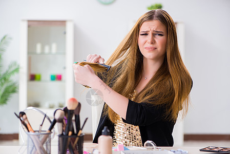 年轻女人对她乱发的头发感到沮丧疾病理发师梳子刷子药物女孩造型师损失剪刀女士图片