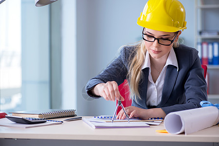 从事该项目工作的女建筑师商务建设者圆规草稿学生办公室工程经理安全帽头盔图片