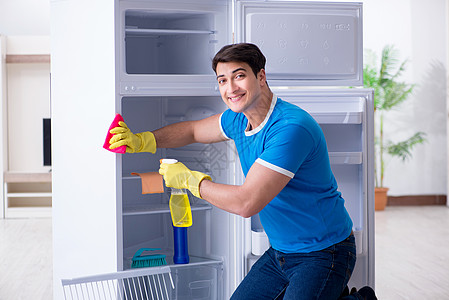 在卫生概念中男人清洁冰箱器具微笑管家家政架子灰尘清洁工家务承包商海绵图片