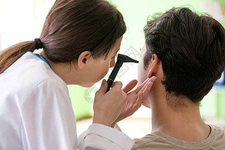 在体检期间检查病人耳部的女医生 女医生听力医师女士耳科微笑男人乐器治疗工具咨询图片