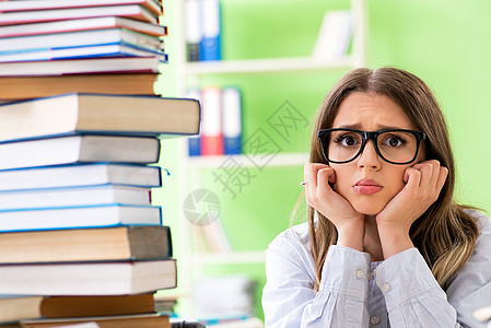 年轻女学生准备参加许多书本的考试班级训练困惑宿舍阅读图书知识学校课堂研究图片
