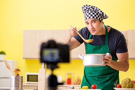 年轻厨师博客解释食物准备情况餐厅拍摄播送钢包盘子示范美食网络食谱男人背景图片