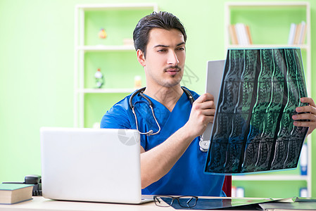 工作在医院的年轻医生男人核磁共振扫描器照相展示保健技术电脑诊所谐振图片